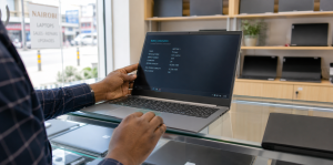 Used laptop buyer checking battery, screen and keyboard in a Nairobi electronics shop
