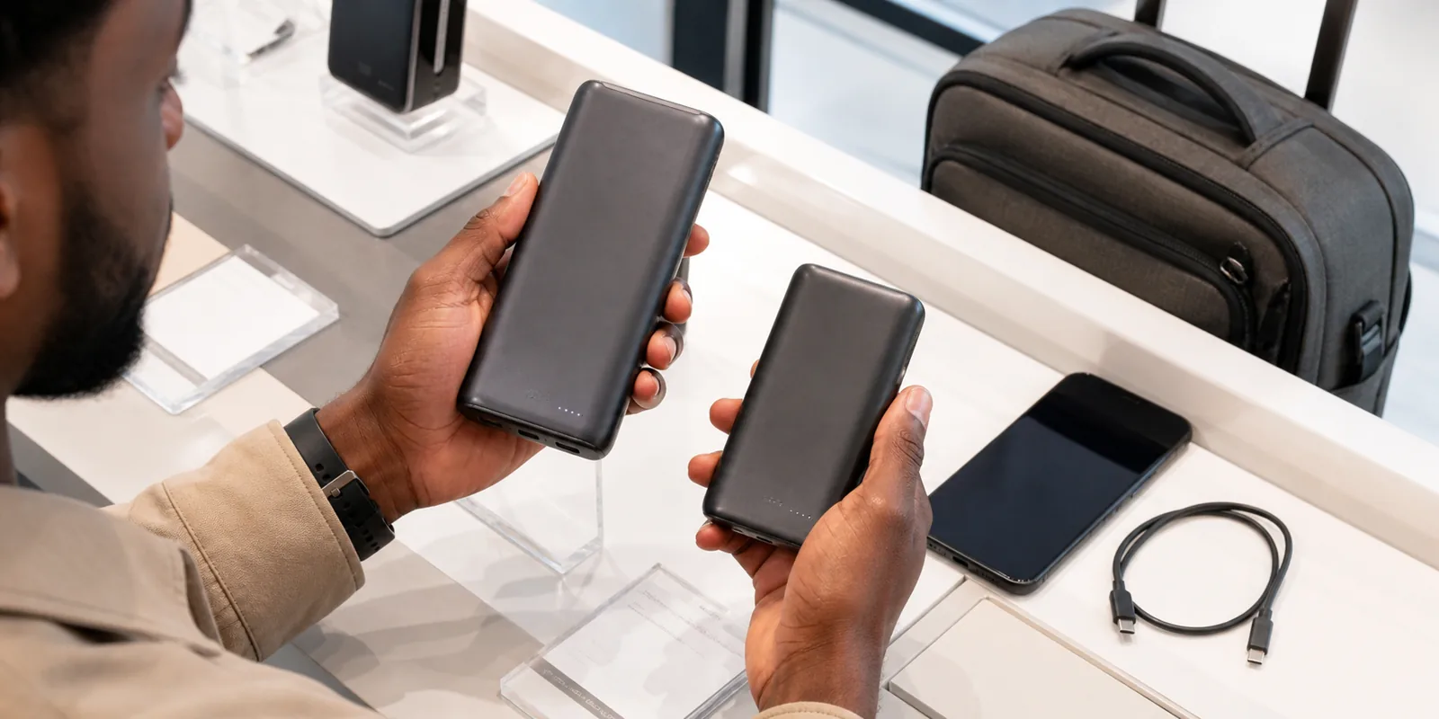 USB-C power bank charging a smartphone with capacity and wattage details visible